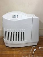 Full view of the white Kenmore humidifier showing front vent slats and overall shape.