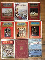 Overview photo showing nine British vintage magazines with ornate red illustrated covers and various other colorful vintage magazine covers, some with photographic imagery and text.