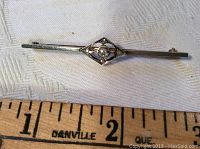 Front view of antique 14k gold bar pin with platinum and diamond center, showing length measurement.