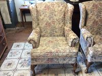 Full frontal view of a floral wingback chair showing fabric pattern and seat cushion.