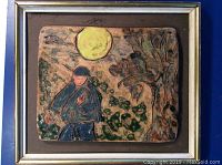 View of the glazed pottery wall art plaque showing a figure near floral shapes under a yellow sun, framed with silver and gold border.