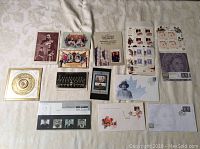 Photo showing entire collection of various vintage stamps, postcards, and royal commemorative envelopes arranged flat on a surface.