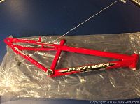 Full view of the red Formula Nucleus BMX aluminum bike frame on plastic sheet.