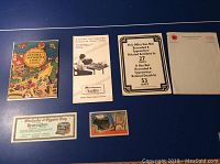 Photo showing the overall lot spread out on blue background: colorful cartoon publication, pamphlet, office safety sign, and ephemera cards.
