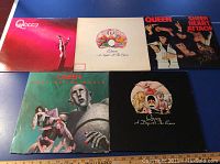 Five Queen vinyl LP records displayed on a flat surface showing front covers of each album.