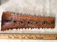 Full view of the wooden swordfish bill with hooks and painted decoration showing the approximate 13-inch length against ruler.