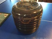 Closed view of the assembled black plastic food dehydrator with transparent dome lid on top.