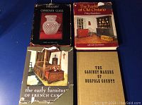 Four hardcover antique reference books displayed laid flat: Treasury of Canadian Glass, The Furniture of Old Ontario, The Early Furniture of French Canada with damaged dust jacket, and The Cabinet Makers of Norfolk County.