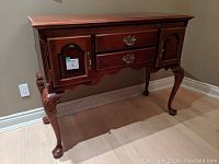 Front three-quarter view of mahogany sideboard showing overall condition, carved apron, and cabriole legs