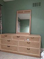 Maple 7-drawer dresser with attached rectangular mirror in a bedroom setting