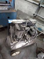 Side view of Sanborn Black Max air compressor showing motor and tank with wheels.