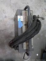 Top view of the Thermal Dynamics Pak Master 25 plasma cutter with attached cables coiled on top, showing model identification label and general wear.