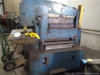 Front view of blue ironworker machine with worktables and control lever