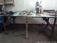 Front view of the large metal industrial table with various tools on the surface