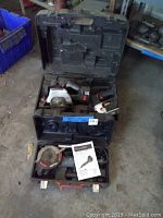 Three stacked hard plastic cases each containing a power saw with the top case housing the Omni dual saw.