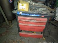 Rubbermaid rolling cart with red drawers and punches on top