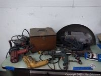 Overview of the lot items including drills, sander, wooden toolbox, accessories.
