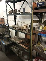 Full view of metal shelving unit loaded with various hardware and electrical items, showing overall contents and condition.