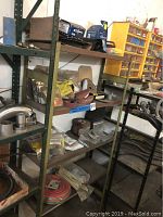 Metal shelving unit loaded with assorted hardware and workshop supplies.