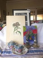 Photo shows Bavarian china cream and sugar set, floral cookie plate, vintage botanical print, original watercolor, and silvered glass candlesticks arranged on cloth.