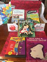 Photo shows multiple children's books including seven Little Golden Books with illustrated colorful covers and one Kids Yoga DVD in a basket on a red cloth.