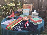 Overall view of fabric, embroidery thread, plant plates, boxes, plaques, frame, aluminum sheet, and other maker supplies on table