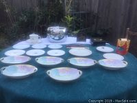 Table spread with vintage porcelain plates, saucers, bowls, a cup, a Penguin branded vintage chrome ice bucket without lid, and muffin liners box.