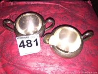 Overhead view showing both pieces, focusing on size, shape, handles, and tarnish marks.