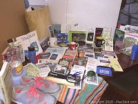 Photo showing hiking and camping guides, maps, camping mugs, and gray/pink Nike athletic shoes