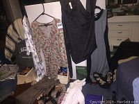 Groups of outfits hanging and laid out with books and shoes visible