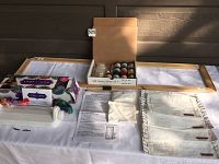 Overview of silk screening wooden stretcher bar frame, paints in box, bracelet maker and pouches laid out on table