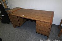 Full view of Biltrite wood desk showing top surface, two drawer banks and rounded front corners.
