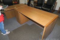 Two-piece large L-shaped wooden corner desk and matching smaller desk with drawers and filing cabinets, showing front view and top surface.