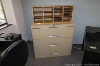 Wood cubbies placed on top of metal file cabinet in office room