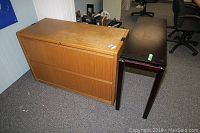 Photo showing wood lateral file cabinet with lock and key, scratches visible