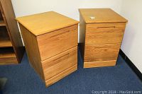 Pair of wooden file cabinets side by side showing front and top.
