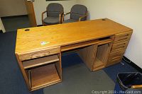 Front view of the Orman Grubb wooden desk showing drawers, keyboard shelf, and open shelving.