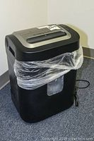 Royal 1620 MX crosscut shredder wrapped in plastic bag, showing front and side with power cord visible.