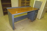 Front angle view of the Equipto work table showing wooden top, metal frame, lower shelf, and caster wheels.