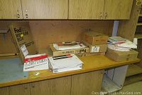Wide view of shipping boxes and envelopes on countertop, featuring FedEx Medium boxes and assorted envelopes