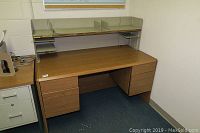 Full view of wood desk showing flat work surface, two drawers on one side and two file drawers on the other side, with shelf and partition organizer on top.