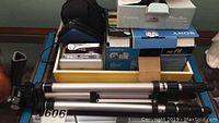 Overview of cameras, boxes and silver tripod included in the lot