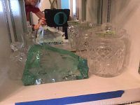 Two clear crystal jars with faceted lids alongside green-tinted glass sculpture