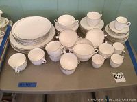 Full set of Royal Worcester china on table showing multiple plates, cups, saucers.