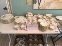 Full overview of the complete set on the table including plates, cups, saucers, and serving bowls arranged with some stacked and others grouped
