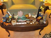 Photo shows the full table with all items including trinket boxes, vases, figurines, and watches arranged for viewing.