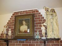 Full view of framed portrait wall art with four figurines on mantel shelf