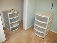 Two plastic drawer storage units placed corner against walls on carpet floor.