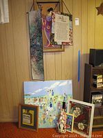 Full lot showing varied wall art including Asian figure prints, wedding painting, stained glass cardinal, paintings, and framed posters.