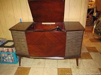 Front angled view of wooden stereo cabinet with top lid open showing turntable inside